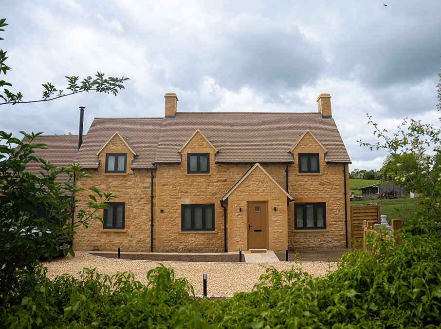 Marleys House Marleys House, a Cotswold stone cottage in Chipping Campden beautifully renovated. This is the front view showing 6 windows and two chimneys. The house is built using Cotswold stone. There's a view of the drive and foliage in the foreground.