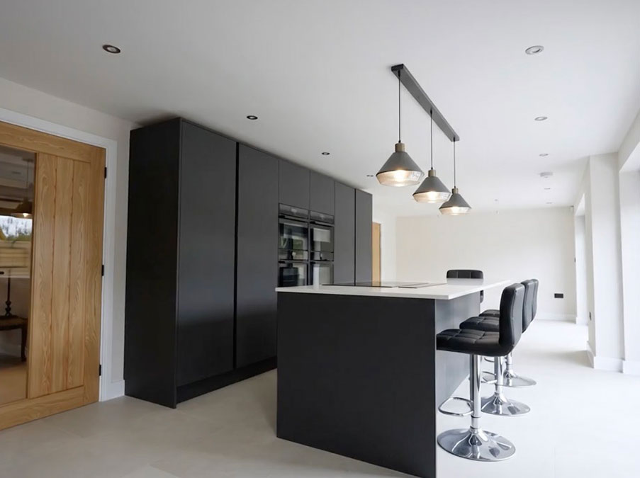 A beautiful black and white kitchen with central island cooking station and breakfast area